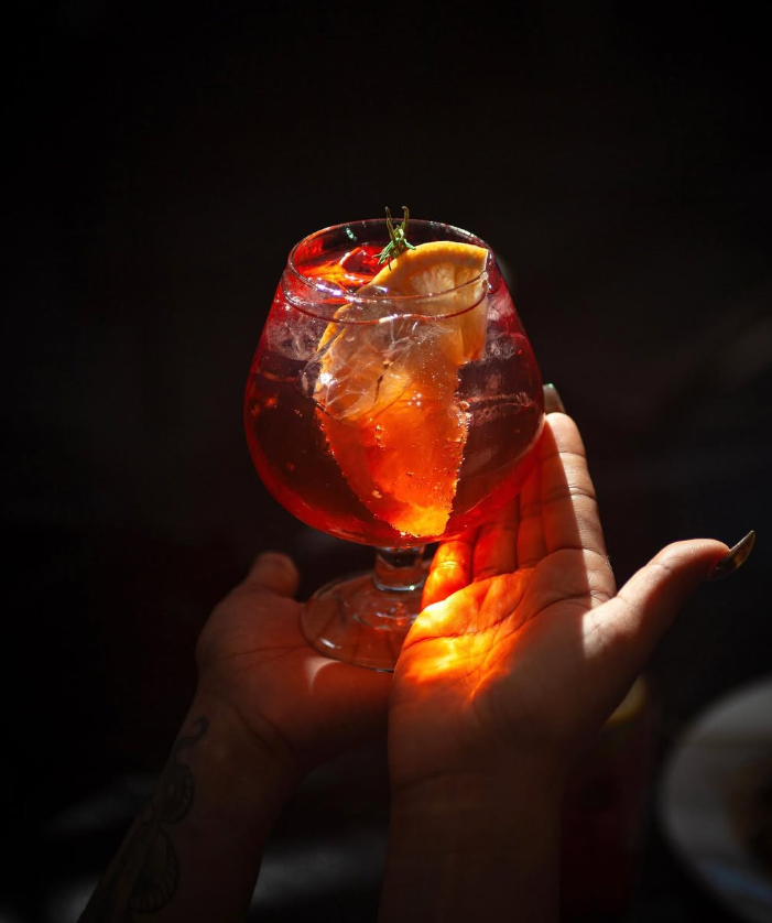 Cóctel rojo en copa con luz dramática